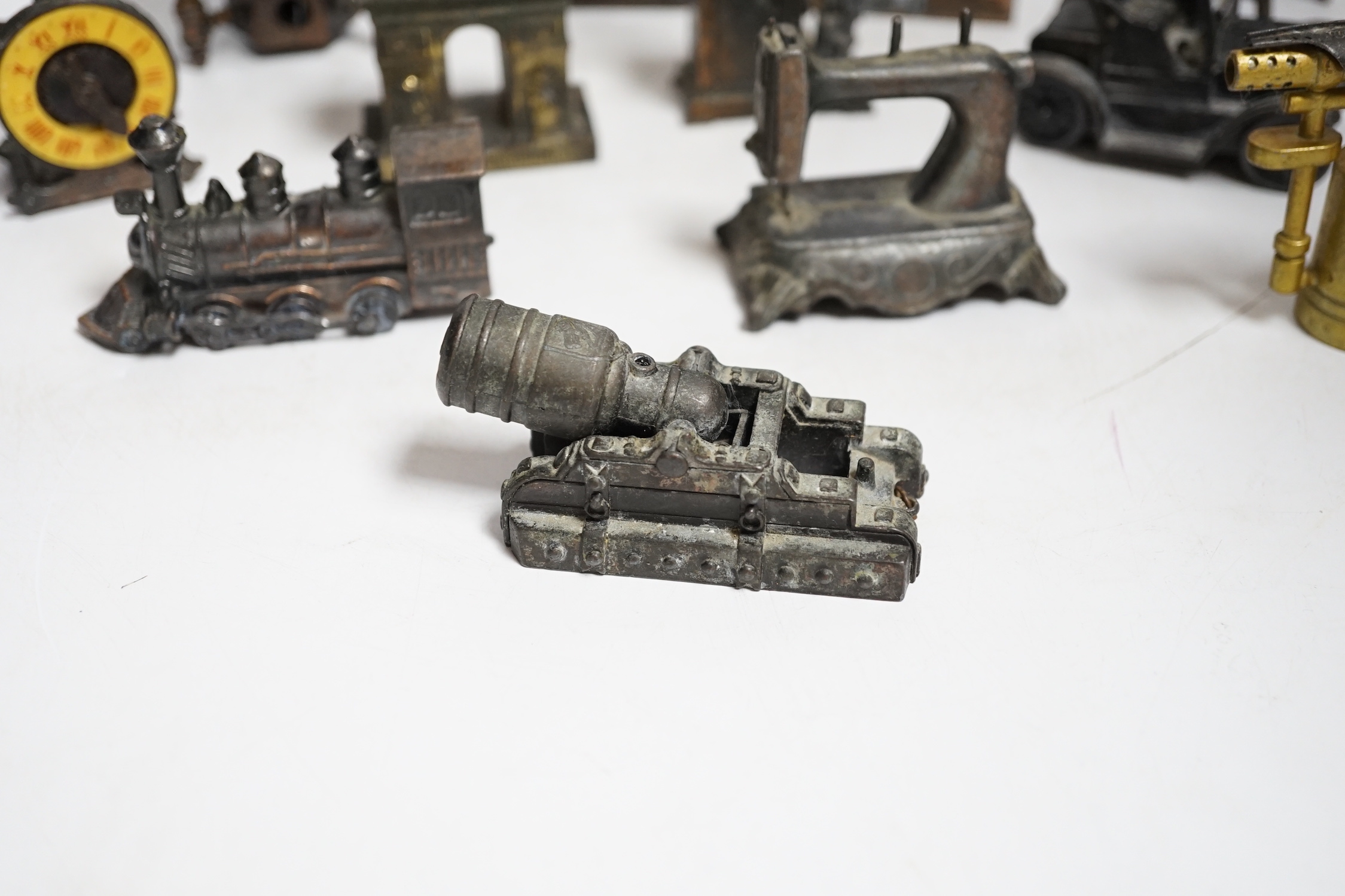 A collection of novelty metal pencil sharpeners and a pair of late Georgian silver plated candlesticks, 20cm